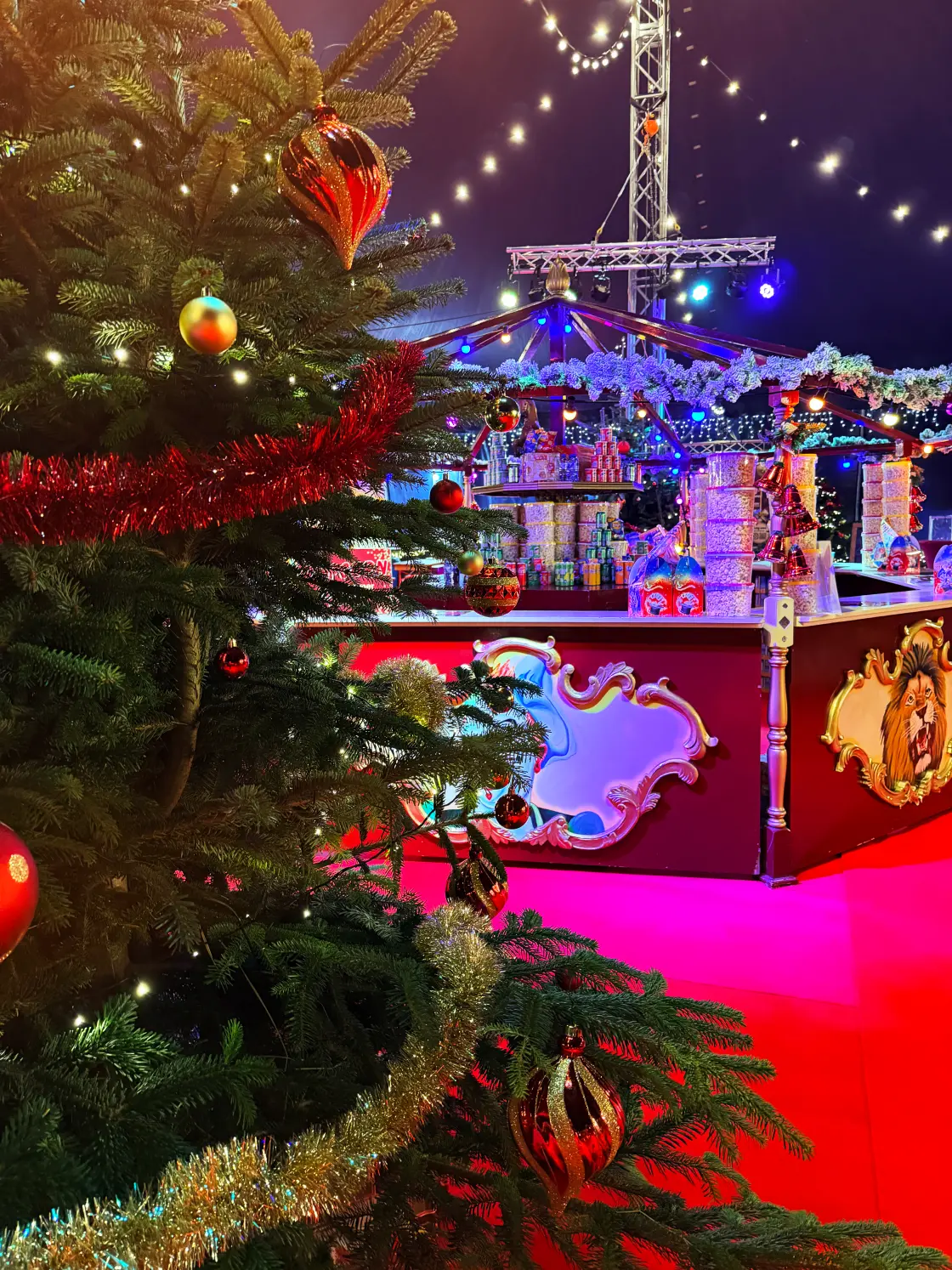 Een versierde kerstboom voor de verlichte bar in de foyertent